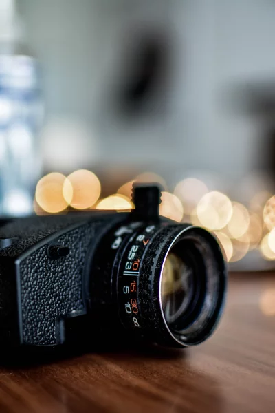 The camera is positioned on a table, pointed at a string of lights in the background