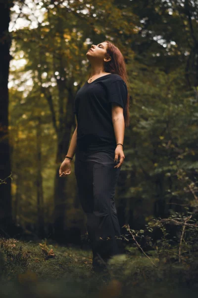 Young Woman Finds Serenity in Sun-Dappled Autumn Forest