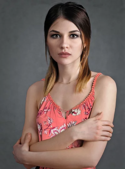 Pensive Young Woman with Crossed Arms in Coral Floral Top image