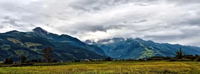 Scenic Mountain Range with Rolling Hills and Dramatic Cloudy Sky image