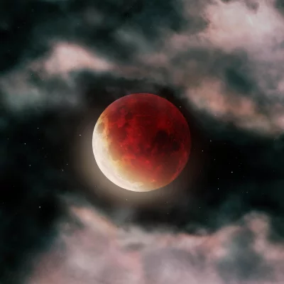 Dramatic Blood Moon Against Starry Night Sky with Ethereal Clouds image