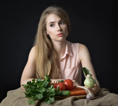 Young Woman Pondering Healthy Vegetables for Cooking on Rustic Table image