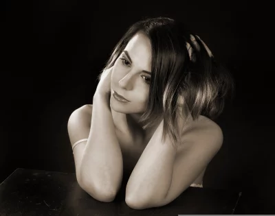 Thoughtful Woman with Short Wavy Hair and Hands to Head Sepia Studio Portrait image