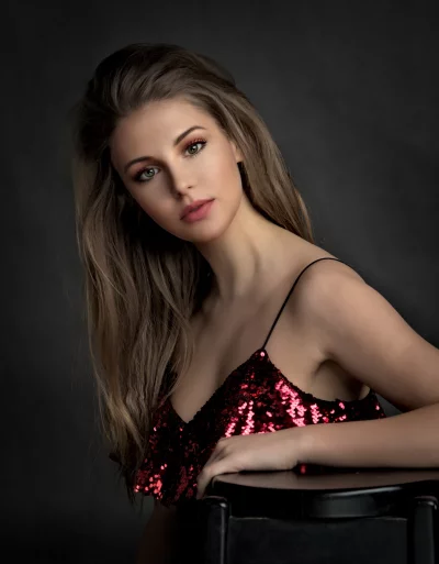 Glamorous Young Woman Posing in Shimmering Red Sequin Top image