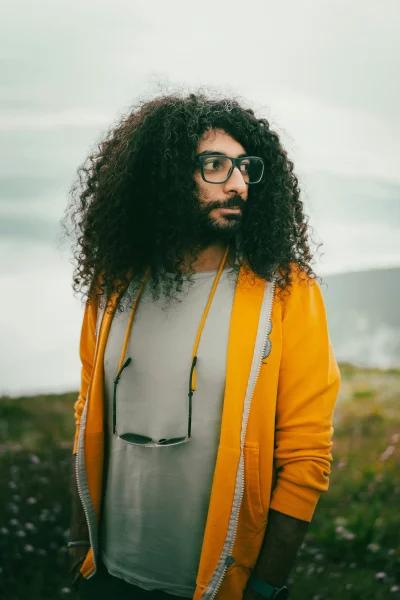 Man with Curly Hair and Yellow Hoodie Outdoors