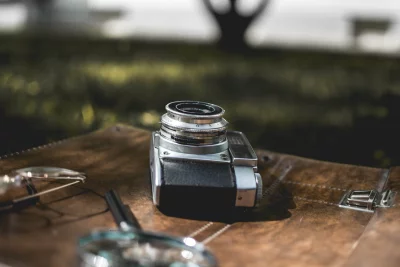 a close-up of a vintage camera lying on a brown leather surface