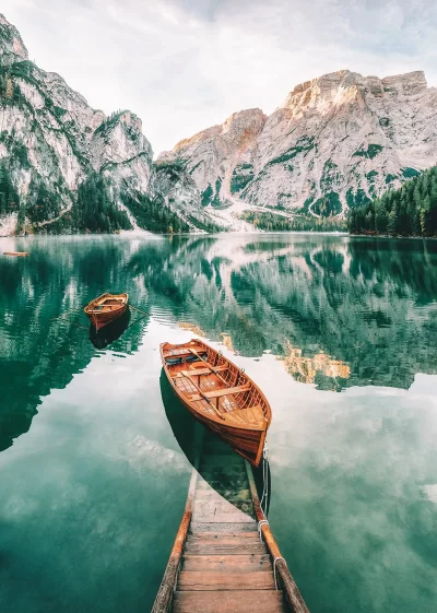 Wooden rowboats dock on serene mountain lake with stunning reflections