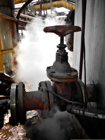 Rusty Industrial Valve Leaking Steam in a Dilapidated Factory Setting image
