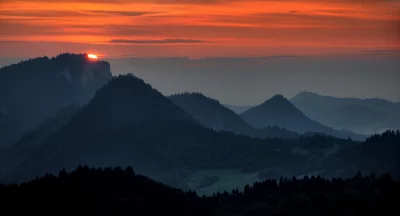 Vibrant Mountain Sunset Over Layers of Peaks and Forest Horizon image