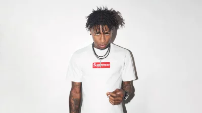 Serious portrait of a stylish young man in a white Supreme t-shirt holding a cigarette image