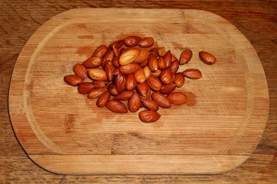 Pile of Golden Roasted Almonds on Rustic Wood Cutting Board image