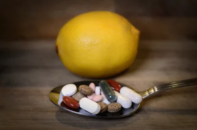 Lemon and Assorted Pills on Spoon for Health and Wellness Choices image