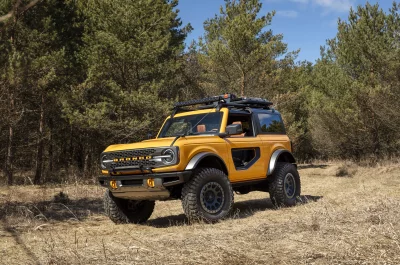 Yellow Ford Bronco Off-Road Adventure in Pine Forest HD Wallpaper image