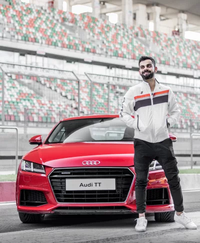 Virat Kohli Posing with Red Audi TT Sports Car at Racetrack for Luxury Lifestyle image