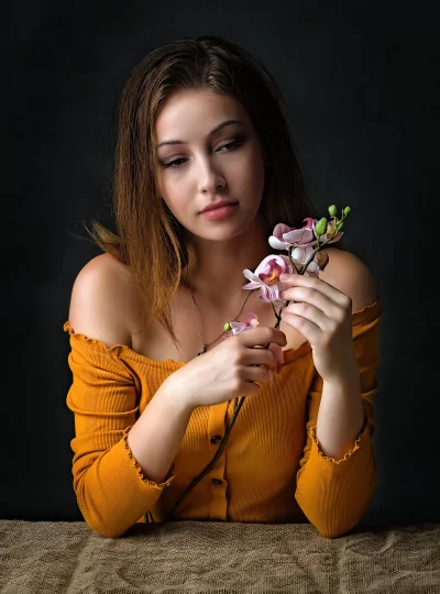 Pensive Young Woman with Delicate Orchid Flowers image