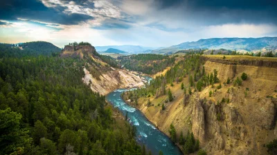 Vibrant Blue River Cutting Through a Majestic Green Mountain Landscape image