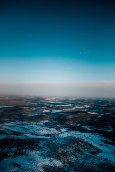 Vast Aerial Winter Forest Landscape with Moon and Blue Sky image