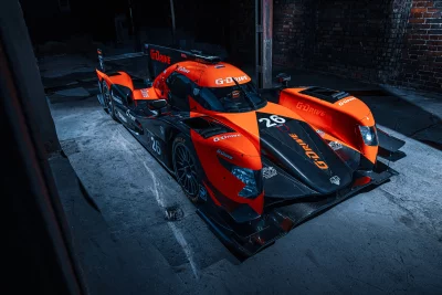 High Performance Orange and Black Racing Car Cinematic Wallpaper in Dark Garage image