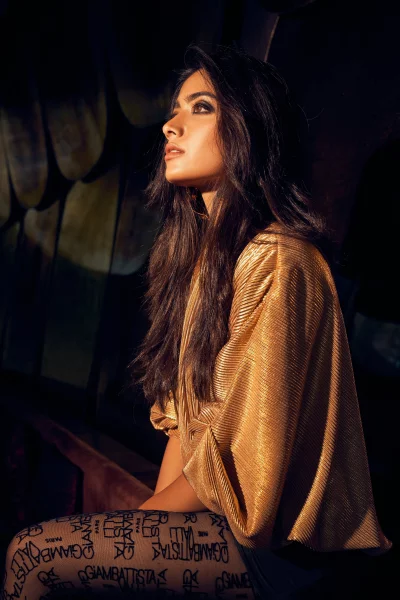 Elegant Young Woman in Golden Pleated Top and Designer Tights with Dramatic Lighting image