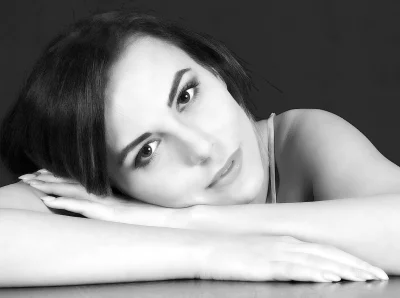 Black and White Portrait of a Thoughtful Young Woman Resting Head on Arms image