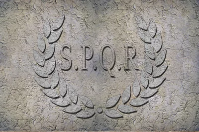 a stone carving of the letters SPQR within a wreath of laurel leaves