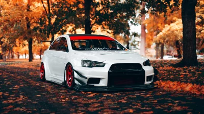 White Modified Performance JDM Car with Striking Red Rims in Scenic Autumn Park image