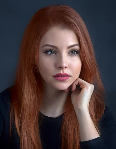 Vibrant Redhead Woman with Thoughtful Expression and Green Eyes image