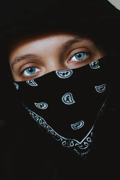 Woman wearing a black bandana that covers her mouth and nose