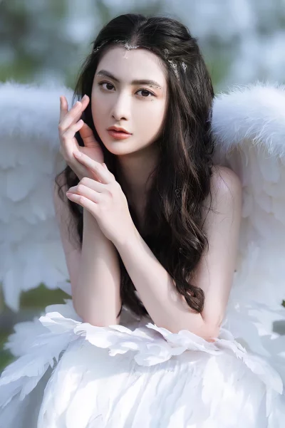 A young woman with long black hair and white wings