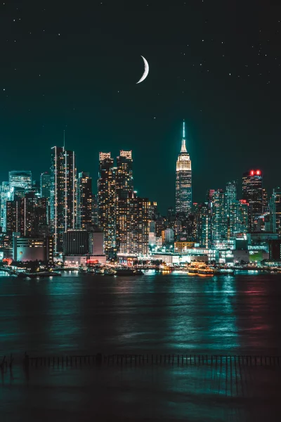 Mesmerizing New York City Skyline at Night with Crescent Moon Reflecting on Hudson River image