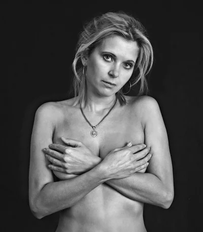 Monochrome Artistic Portrait of Pensive Woman Covering Herself with Crossed Arms image