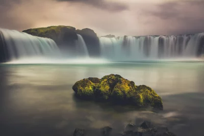 Majestic Icelandic Waterfall with Moss-Covered Rocks Long Exposure image