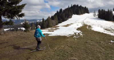 Woman Cross-Country Skiing on Snowy Mountain Slope in Early Spring image