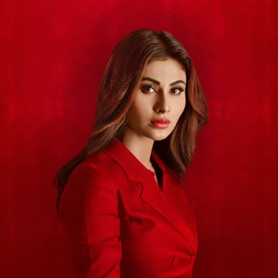 Mouni Roy in Red Blazer with Intense Gaze on Textured Red Background image
