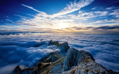 Majestic Mountain Peaks Above Clouds at Golden Sunset image