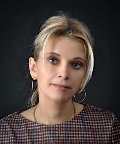 Thoughtful Blonde Woman in Plaid Dress with Blue Eyes and Gold Jewelry image
