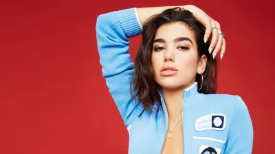 Dua Lipa Posing in Blue Track Jacket on a Red Studio Backdrop image