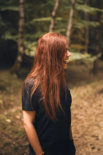 Joyful Redhead Woman Smiling in a Natural Forest Environment