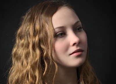 Thoughtful Young Woman with Flowing Wavy Hair Portrait on Dark Background image