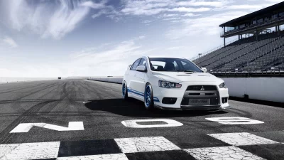 White Mitsubishi Lancer Evolution X Performance Car on Racetrack with Grandstands image
