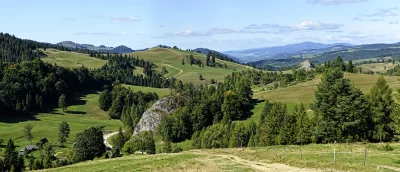 Panoramic Mountain Valley Landscape with Winding Path, Green Hills, and Lush Forest image