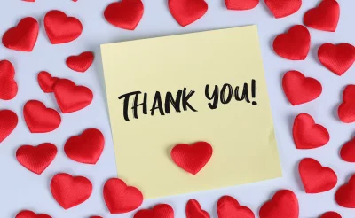 Heartfelt Gratitude Message on Yellow Sticky Note Adorned with Romantic Red Fabric Hearts image