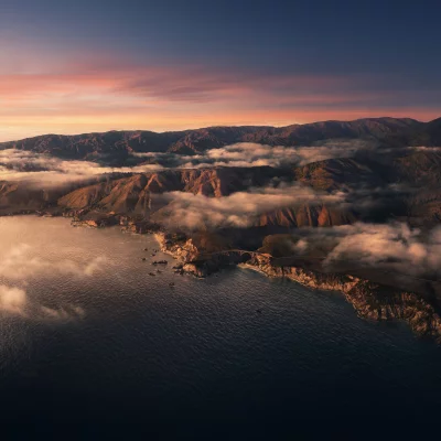 Coastal Mountains and Iconic Bridge at Golden Hour with Rolling Fog image