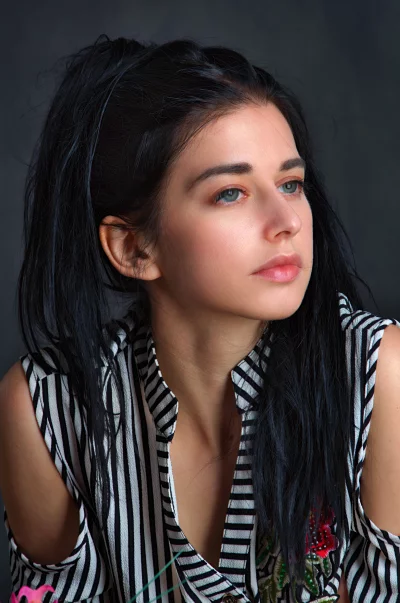 Beautiful Woman with Long Dark Hair Gazing Away in a Black and White Striped Shirt image