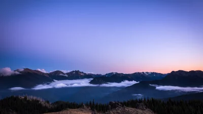 Majestic Mountain Range at Twilight with Inverted Clouds and Evergreen Forests image