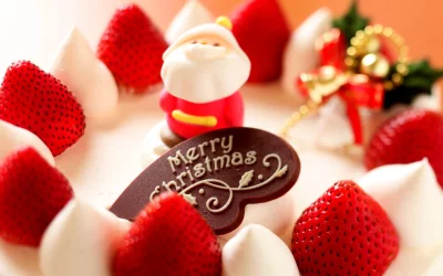 Festive Christmas Cake Adorned with Fresh Strawberries, Santa Figurine, and Chocolate Message image