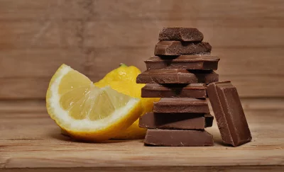 Stacked Chocolate Bars with Fresh Lemon Slices on Rustic Wood image