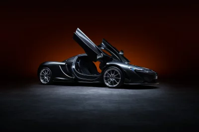 Sleek Dark McLaren P1 Supercar with Open Dihedral Doors in Studio Lighting image