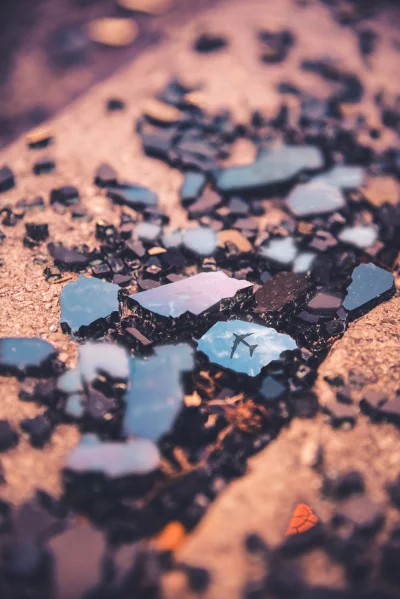 Surreal Airplane Reflection: Broken Glass Shards on Earthy Ground image
