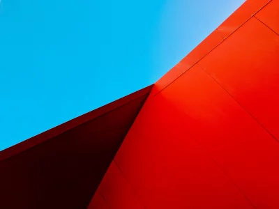 Striking Red Building Facade Against Clear Blue Sky Abstract Architecture image